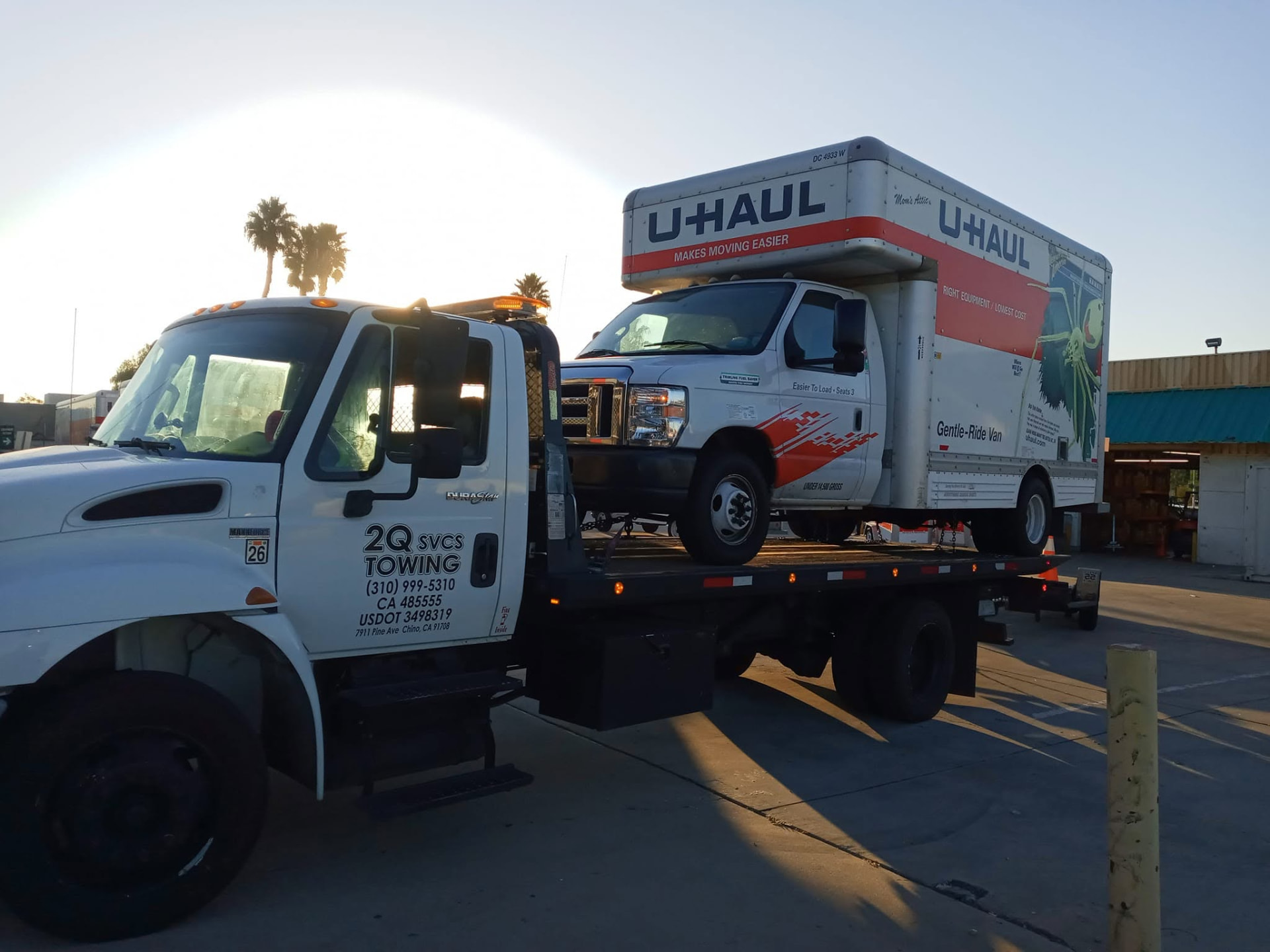 U-Haul box truck loaded on a 2Q Svcs & Towing flatbed