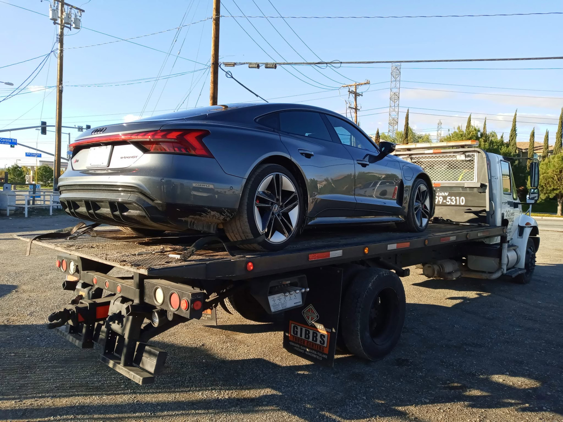 Tow truck operator securing a car onto a flatbed