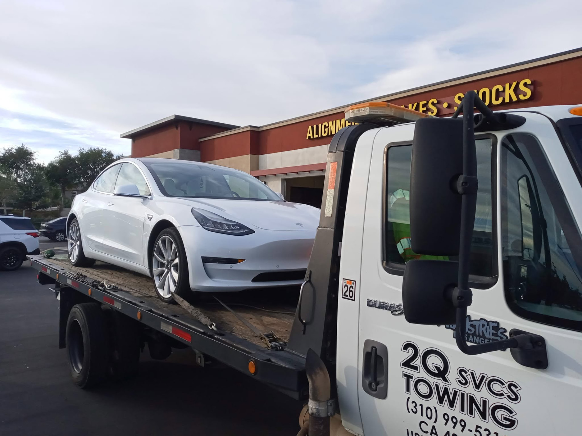 Professional tow truck operator standing in front of a tow truck